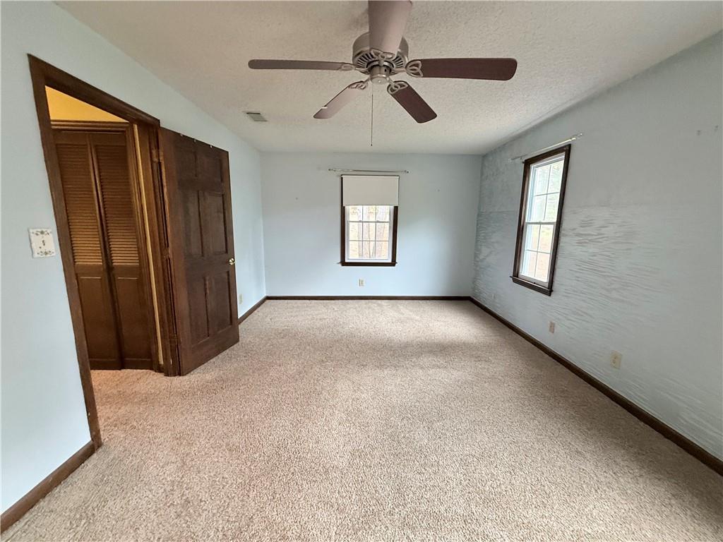 3033 Riviera Drive Conyers, GA 30012 - Photo 30 of 79 an empty room with windows and fan