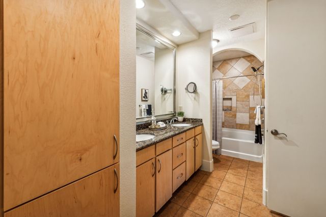 a bathroom with a granite countertop sink mirror and a shower