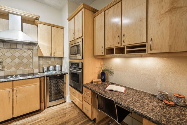 a kitchen with stainless steel appliances granite countertop a stove a sink and a microwave