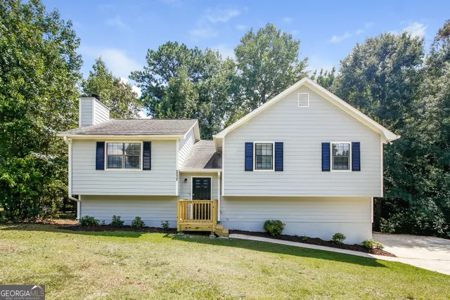 a view of a house with a yard balcony and a tree