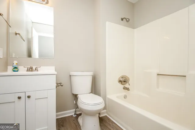 a bathroom with a bathtub shower sink vanity and toilet