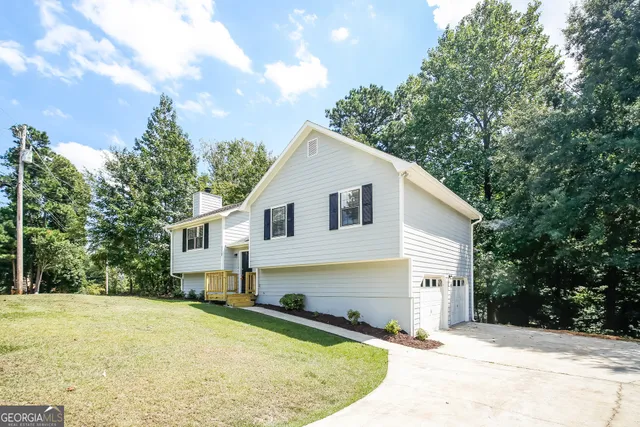 a view of a white house with a yard and potted plants