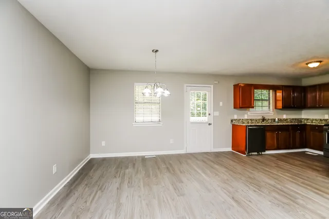 an empty room with kitchen and window