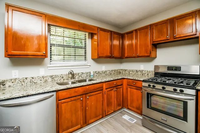 a kitchen with stainless steel appliances granite countertop a sink stove and cabinets