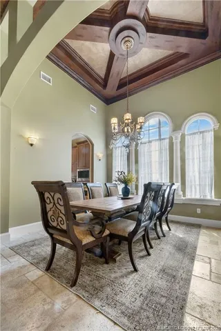 a living room with furniture kitchen view and a chandelier