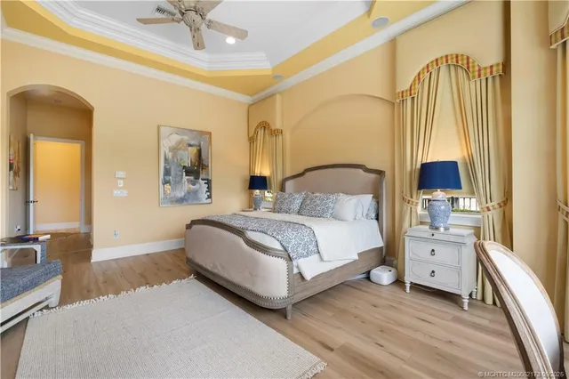 a spacious bedroom with a bed a mirror and a table