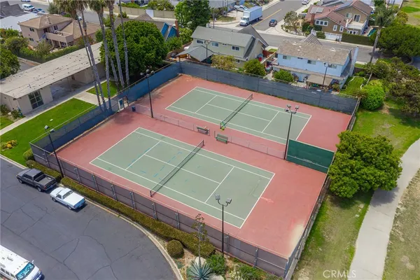 an aerial view of a tennis ground with a white house