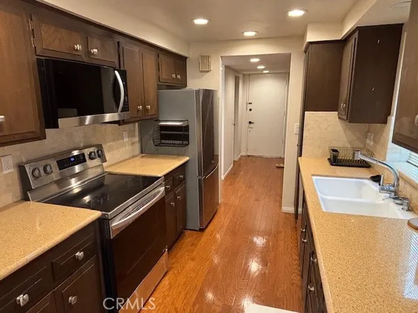 a kitchen with stainless steel appliances a sink stove and refrigerator