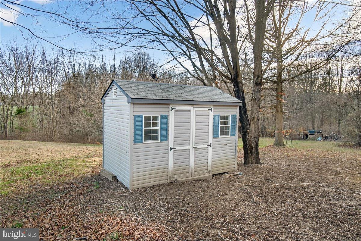6918 Woodville Road Mount Airy, MD 21771 - Photo 46 of 46 Charming shed nestled in serene nature.