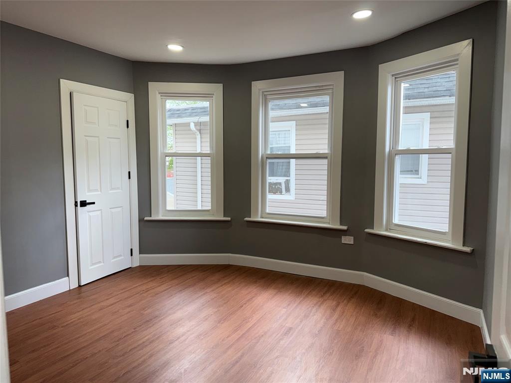 178 Berry Street Hackensack, NJ 07601 - Photo 9 of 22 an empty room with wooden floor and windows