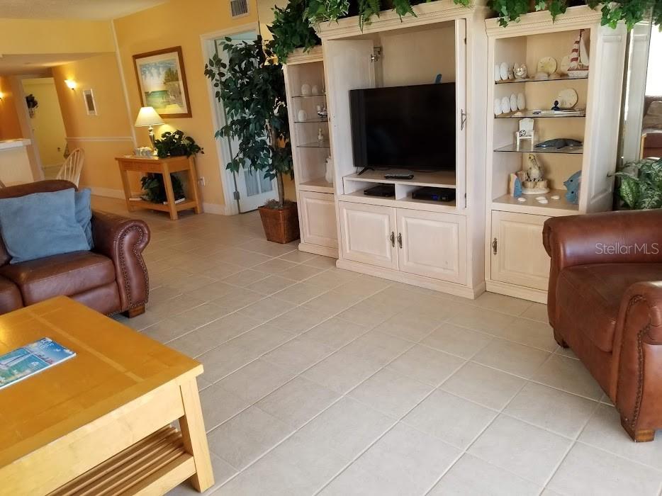 13650 Gulf Boulevard, Unit 304 Madeira Beach, FL 33708 - Photo 32 of 63 a living room with furniture and a flat screen tv