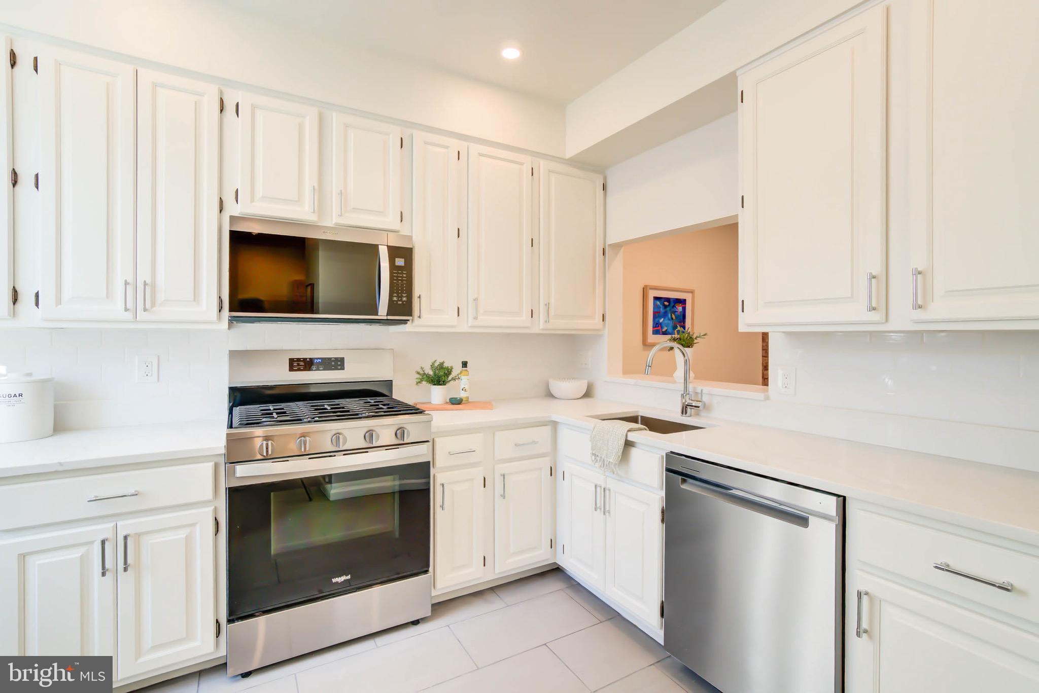 240 14th Street Southeast Washington, DC 20003 - Photo 4 of 14 a kitchen with white cabinets and stainless steel appliances