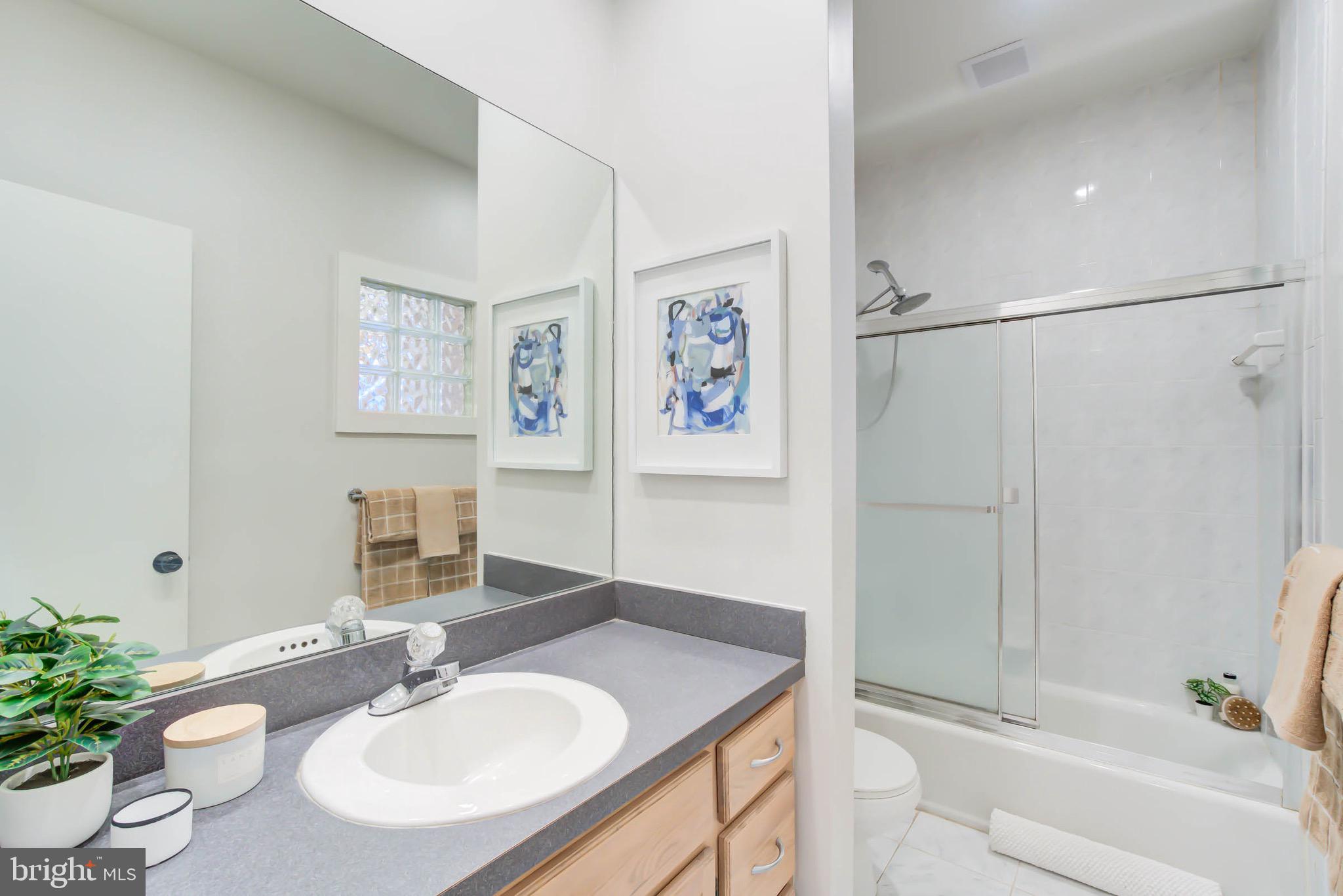 240 14th Street Southeast Washington, DC 20003 - Photo 10 of 14 a bathroom with a granite countertop sink a mirror a shower and a bathtub
