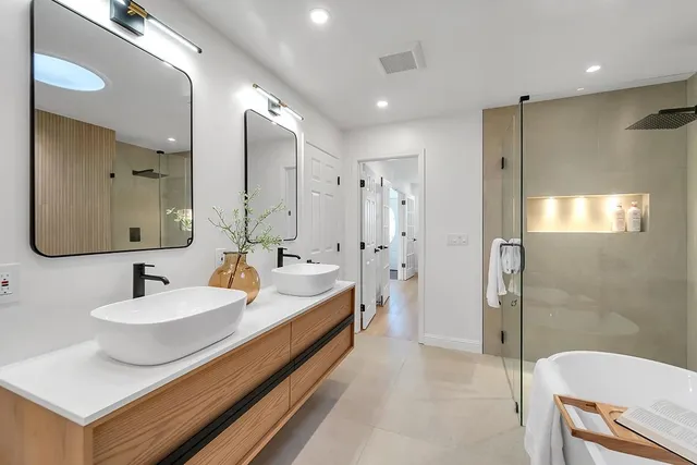a bathroom with a double vanity sink mirror and shower