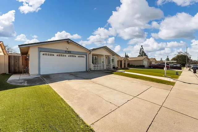 a view of a house with a big yard and large trees