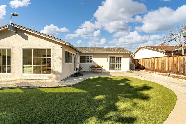 a backyard of a house with table and chairs
