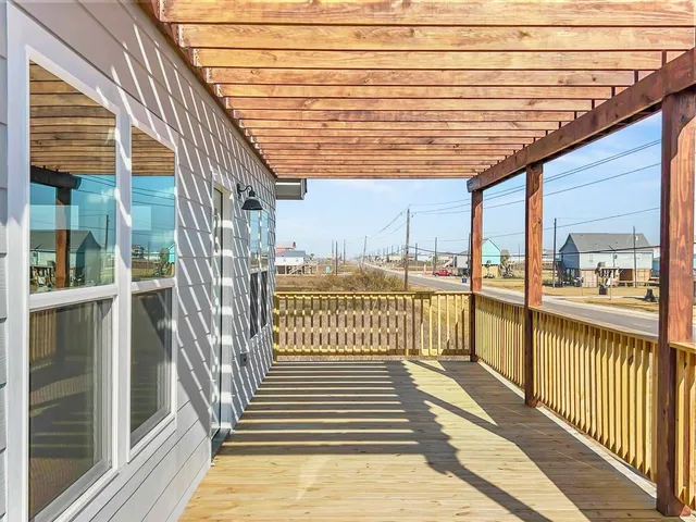 a view of a balcony with wooden floor and fence