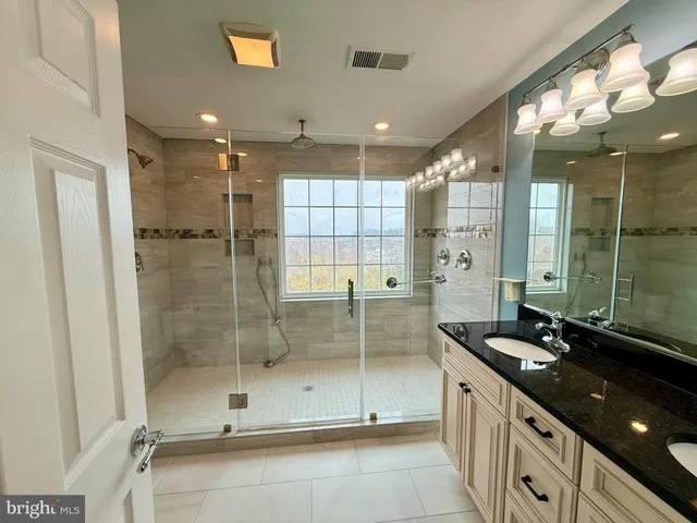 a bathroom with a granite countertop sink mirror and shower