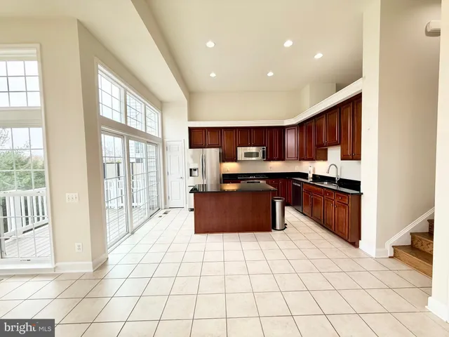 a kitchen with stainless steel appliances granite countertop a stove top oven a sink a counter top space and cabinets