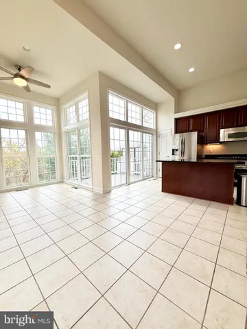 a large kitchen with a stove a sink dishwasher and a refrigerator with wooden cabinets