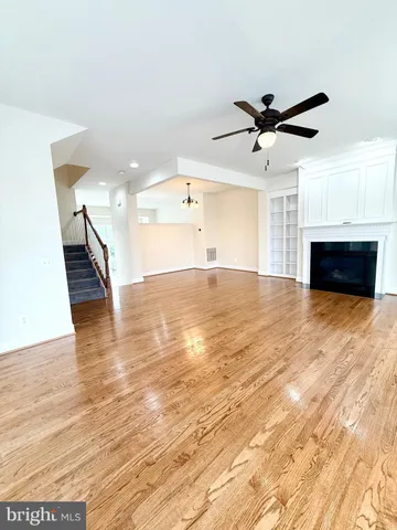 a view of empty room with wooden floor and fireplace