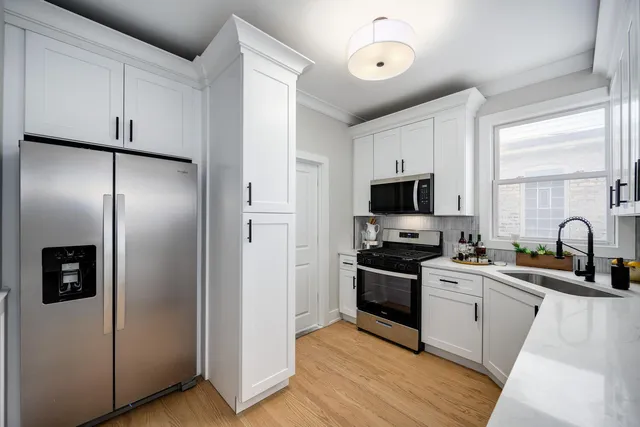 a kitchen with stainless steel appliances a refrigerator a sink a stove a microwave a counter space and cabinets