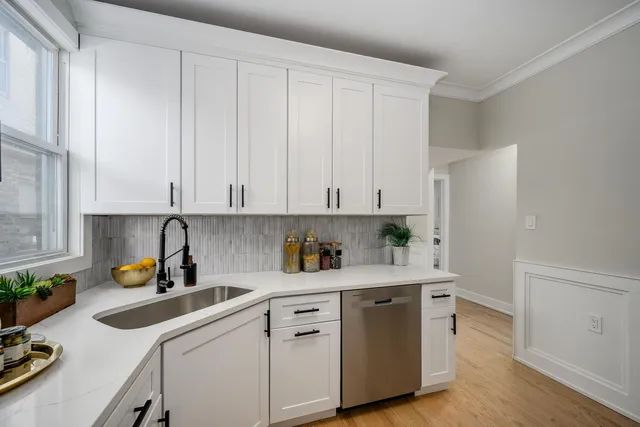 a kitchen with stainless steel appliances white cabinets and a refrigerator
