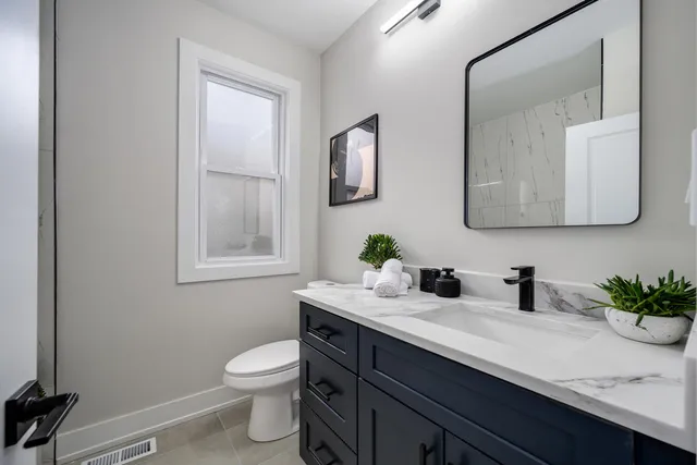a bathroom with a toilet sink and mirror