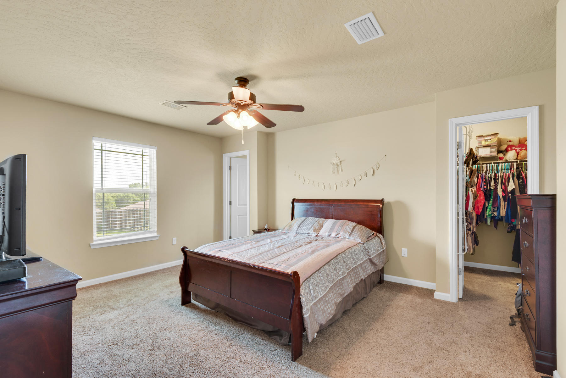 5250 Moore Loop Crestview, FL 32536 - Photo 18 of 34 a spacious bedroom with a bed and a chandelier