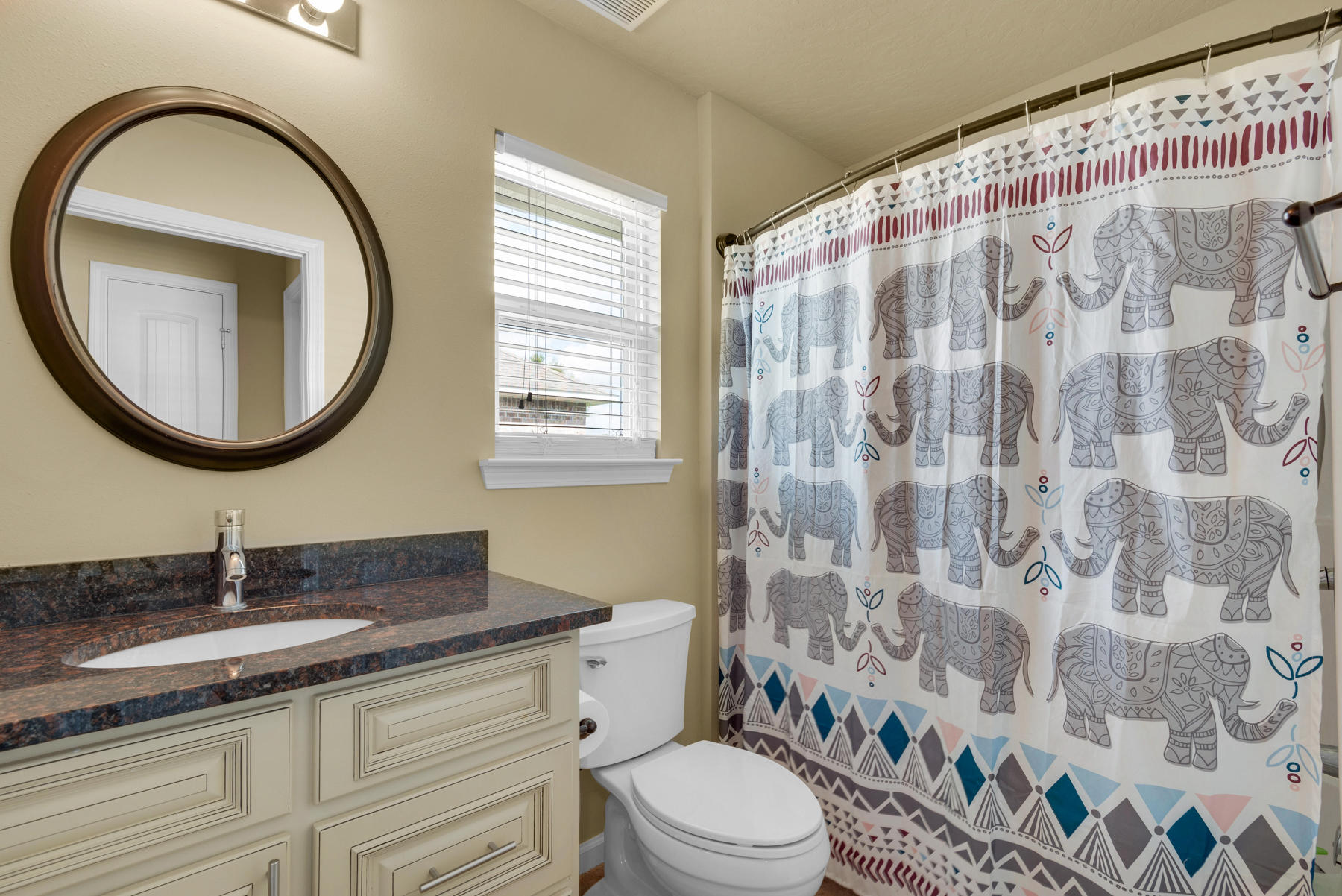 5250 Moore Loop Crestview, FL 32536 - Photo 24 of 34 a bathroom with a granite countertop toilet a sink a mirror a lamp a window and a shower