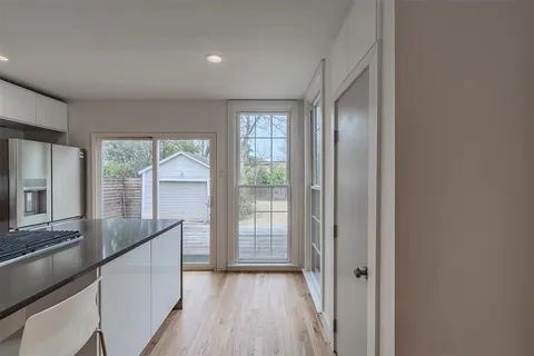 a view of hallway with wooden floor and fan