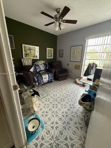 a backyard of a house with lots of plants and large tree