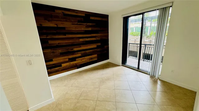 a view of an empty room with wooden floor and windows