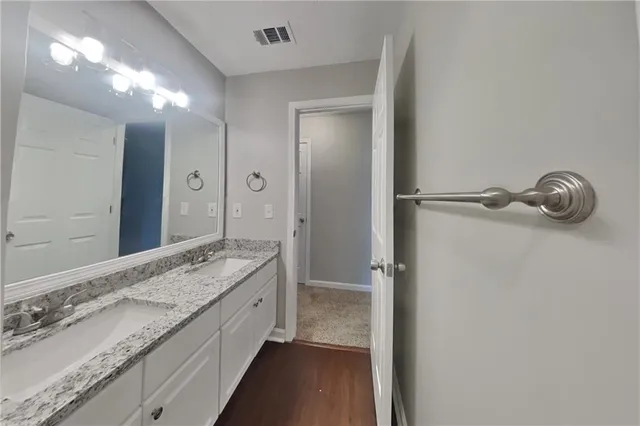 a bathroom with a granite countertop sink and a mirror
