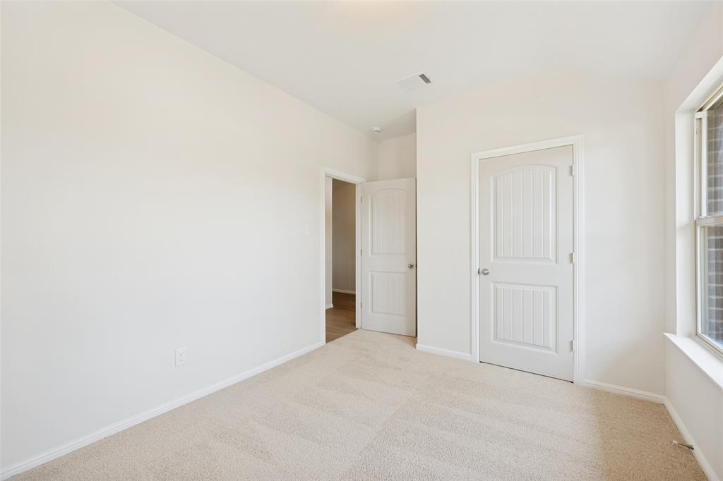857 Watson Way Crowley, TX 76036 - Photo 13 of 25 Neutral-toned room featuring a window with grid patterns, light beige carpeting, and two white paneled doors