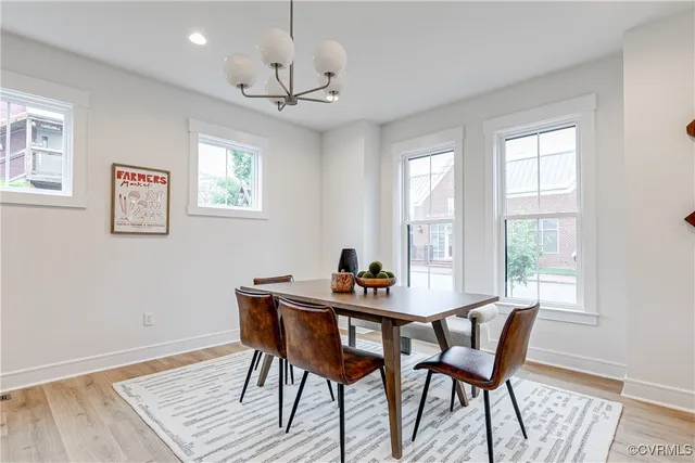 a dining room with furniture a chandelier and wooden floor