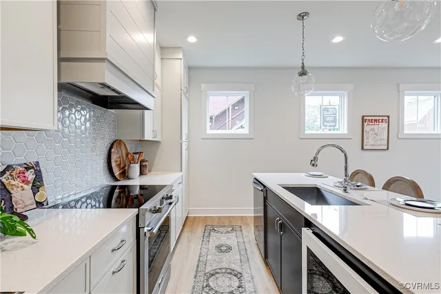 a kitchen with stainless steel appliances a sink stove and cabinets