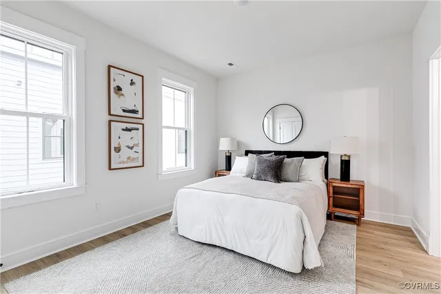 a bedroom with a bed mirror and window