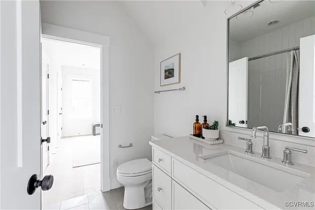 a bathroom with a sink toilet vanity and shower