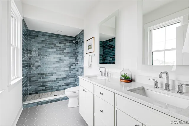 a bathroom with a double vanity sink toilet and shower
