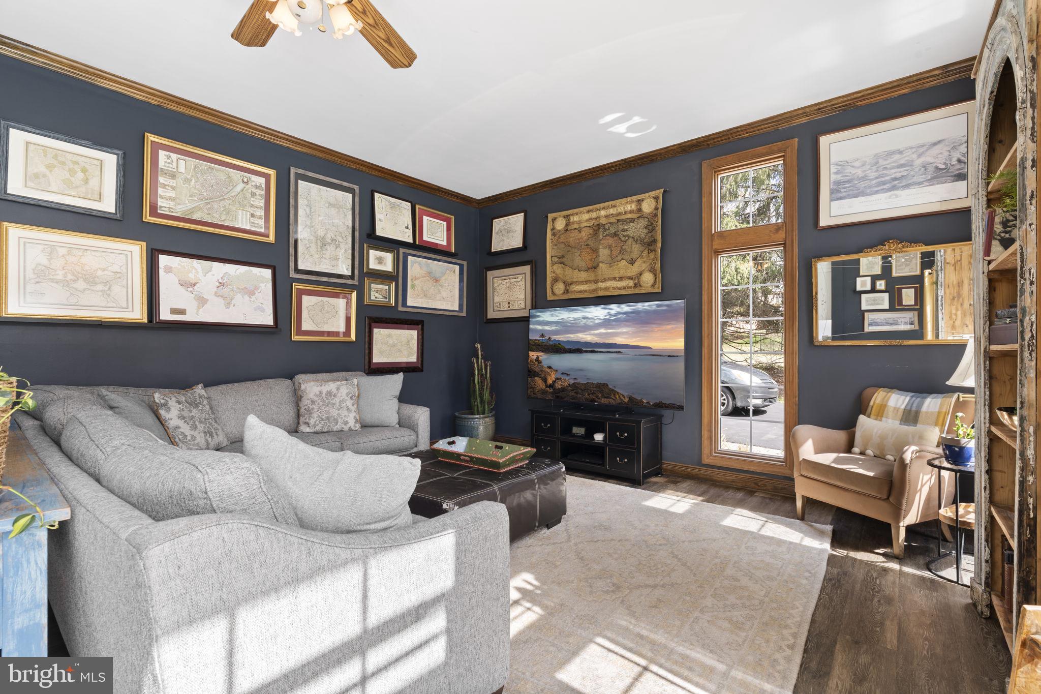 1017 Scholl Road Pottstown, PA 19465 - Photo 18 of 56 a living room with furniture two large windows and a fireplace