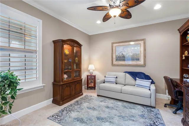 a living room with furniture a bookshelf and a flat screen tv