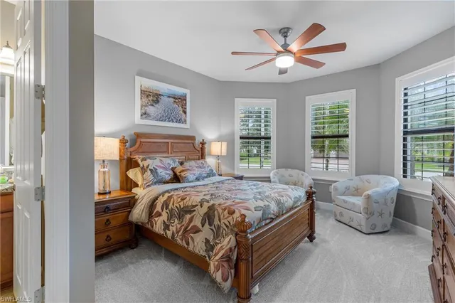 a bedroom with a bed and a table with paintings on the dresser