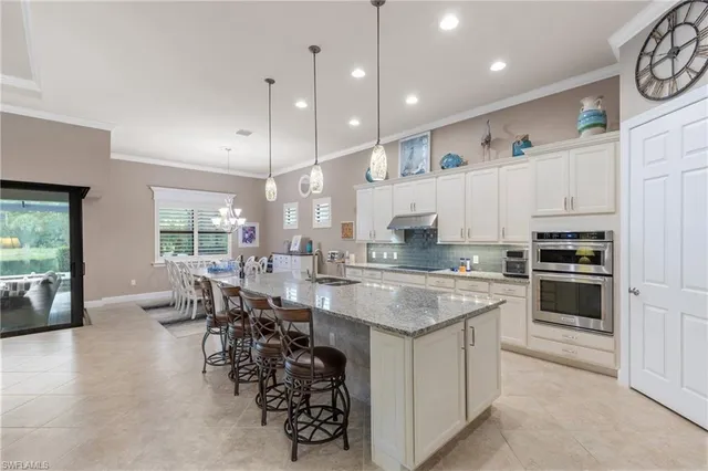 a living room with furniture a ceiling fan and a large window