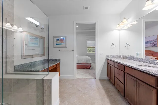 a bedroom with a bed and a lamp on dresser