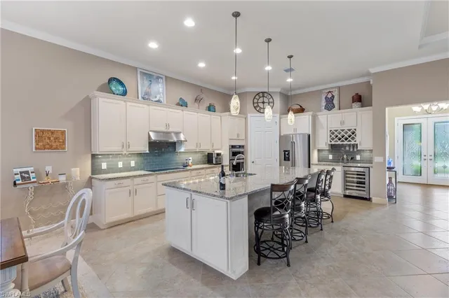 a kitchen with stainless steel appliances kitchen island granite countertop a table and chairs in it