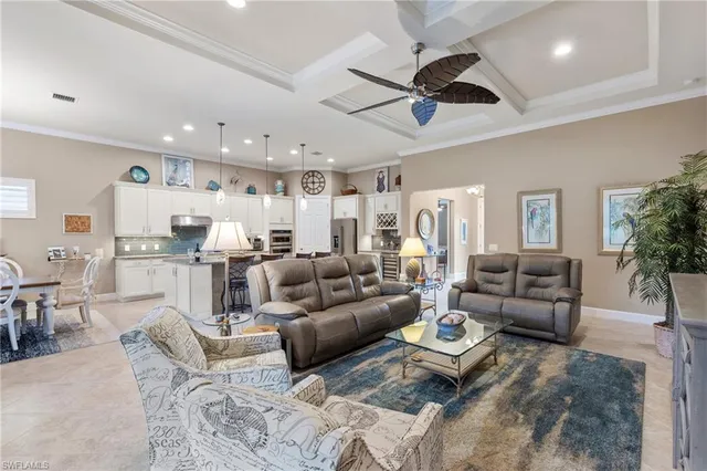 a living room with furniture kitchen view and a chandelier