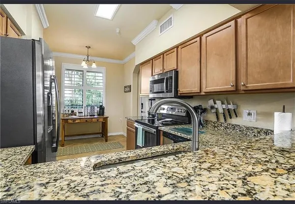 a kitchen with stainless steel appliances granite countertop a refrigerator and a sink