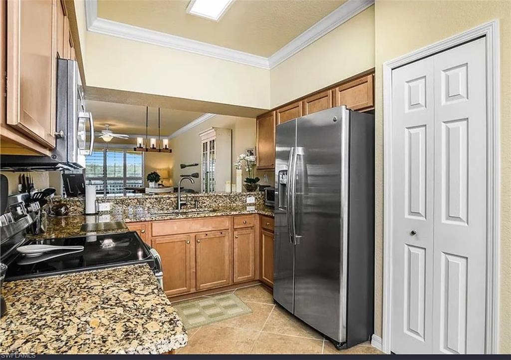 9566 Trevi Court, Unit 4935 Naples, FL 34113 - Photo 13 of 20 a kitchen with stainless steel appliances granite countertop a refrigerator and a sink