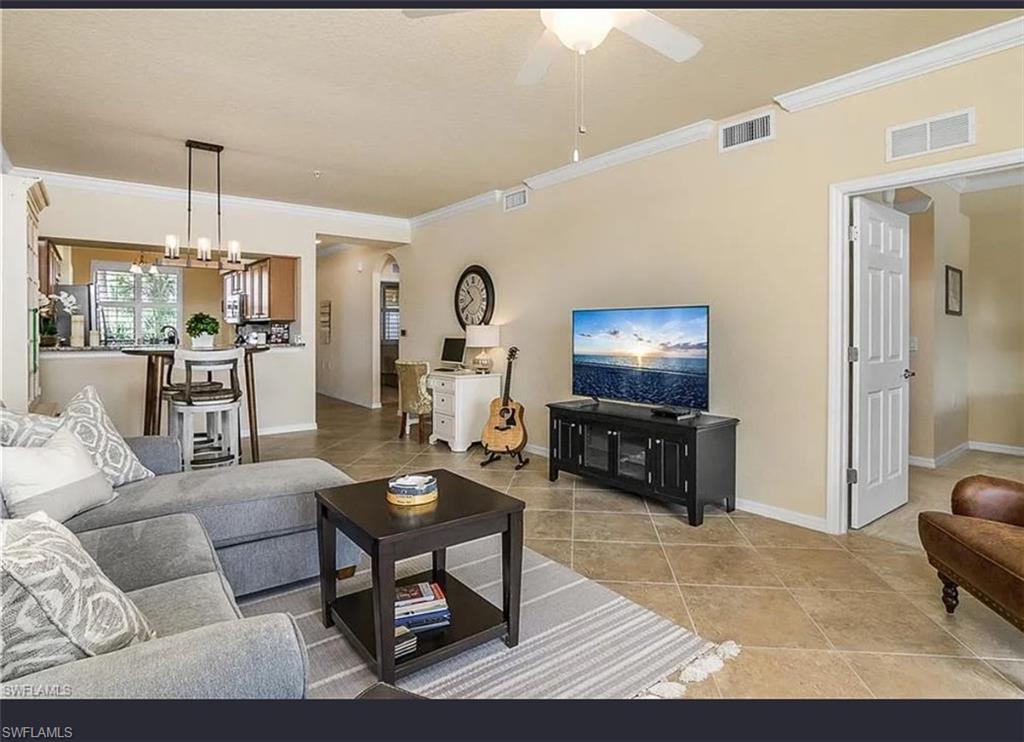 9566 Trevi Court, Unit 4935 Naples, FL 34113 - Photo 20 of 20 a living room with furniture and a flat screen tv